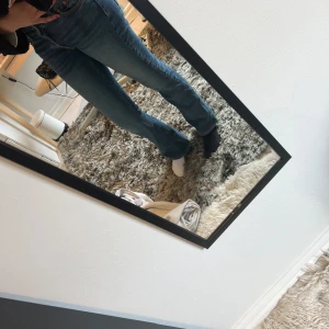 Blå bootcut jeans - Säljer ett par snygga blå bootcut jeans med klassisk femficksdesign och kontrasterande sömmar. Perfekta för en avslappnad stil. Passar bra till både sneakers och klackar.