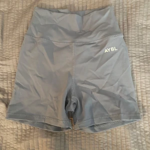Grå träningsshorts från AYBL - Snygga grå träningsshorts från AYBL med hög midja. Perfekta för gymmet eller löprundan. De är tillverkade i ett stretchigt syntetmaterial som ger bra rörelsefrihet. Aldrig använda 