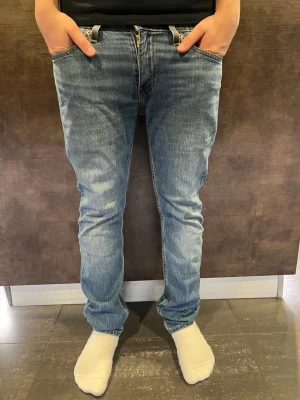 Levi's  - Säljer ett par klassiska Levi's 511 jeans i blå denim. Modellen är slim fit med normal midja och raka ben. Jeansen har fem fickor, gylf med dragkedja och den ikoniska Levi's-lappen bak i midjan. Perfekta för en avslappnad och stilren look.