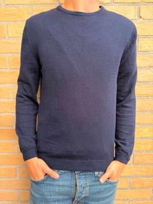 Mörkblå tröja (stenströms) - Tjena säljer nu en mörkblå tröja med rund halsringning och långa ärmar. Tröjan har en enkel, klassisk design utan synliga loggor eller mönster. Tillverkad i ett mjukt, tunt stickat material. Tröjan är från stenströms och är köpt från NK i Göteborg. Tröjan har ett litet hål på ärmen men syns inte tydligt! Storlek M, men sitter mer som S