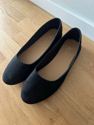 Svarta klassiska ballerinaskor - Ett par stilrena svarta ballerinaskor med rund tå och låg klack. Endast använda en gång! 