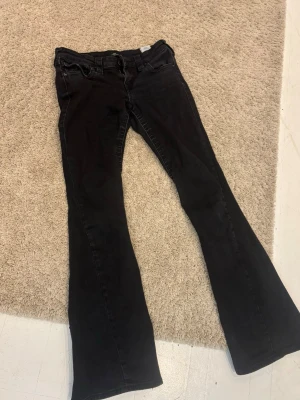 Svarta true religion jeans  - Säljer ett par lågmidjade svarta bootcut jeans från true religion. Har använt några gånger men nu kommer de inte till användning mer. Dom är lite slitna längst ner men annars är dom i mycket bra skick.