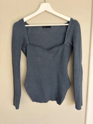 Blå ribbstickad topp med fyrkantig ringning - Trendig blå ribbstickad topp från SHEIN med lång ärm och snygg fyrkantig ringning. Figurnära passform och mjukt stretchigt material som sitter skönt. Perfekt till jeans eller kjol för en cool look.
