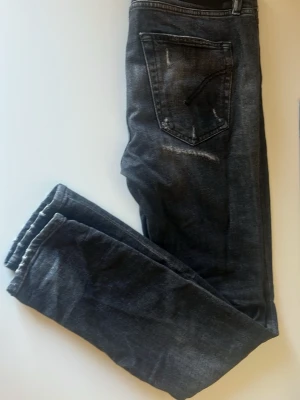 Dondup w30 - Säljer dessa svarta dondup jeans med små slitningar. Jeans sitter bra för dig som gillar slim fit. Jeansen är lite sönder vid gylfen men det syns inte när du går med dem därav priset                                                               Hör av dig vid frågor eller bilder  