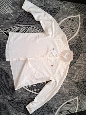 Vit skjorta från U.S. Polo Assn - Klassisk vit skjorta från U.S. Polo Assn med broderad logga på bröstet. Skjortan har lång ärm, knappar framtill och button-down krage. Tillverkad i bomull för en bekväm och luftig känsla. Perfekt till både jeans och chinos.