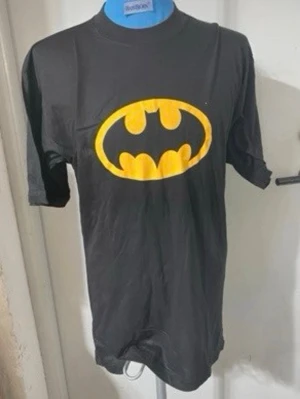 Svart Batman t-shirt med tryck - Cool svart t-shirt med det klassiska Batman-loggan i gult på bröstet. T-shirten har rund hals och korta ärmar, perfekt för dig som gillar superhjältar och vill sticka ut lite extra.   Stlk L  men finns S,M och XL kvar , helt ny 
