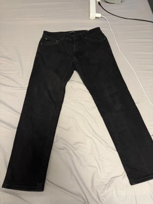 Svarta raka jeans från Jack and Jones  - Storlek 31/30, inga defekter. Modell regular/clark. Säljer ett par svarta jeans med rak passform och klassisk femficksdesign. Jeansen har normal midja och är tillverkade i ett slitstarkt denimtyg. Perfekta för dig som gillar en enkel och stilren look.