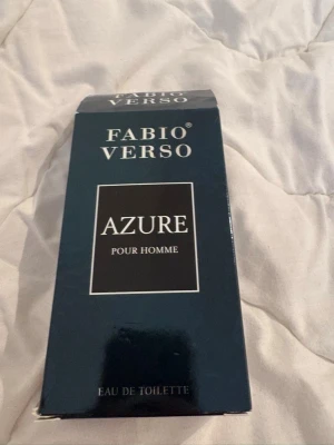 Fabio Verso Azure Pour Homme EdT - Fräsch herrparfym från Fabio Verso, Azure Pour Homme. Flaskan är genomskinlig med räfflad design och blåaktig ton, och har ett mörkt lock. Kommer i en stilren blå kartong. Eau de toilette som passar dig som gillar maskulina, fräscha dofter. Säljs för 160kr är 90 ml
