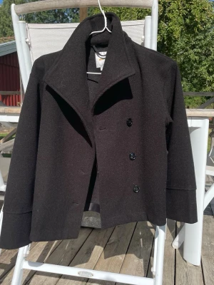 Svart ullkappa med bred krage - Svart superfin kappa. Från Gina tricot i strl 146/152. Kan användas öppen eller stängd. Använd några gånger men i fint skick! Kan anpassa priset vid snabb affär