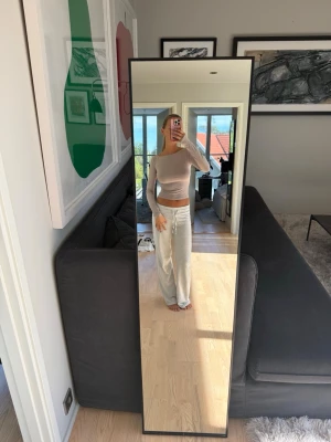 Beige långärmad croppad topp - Säljer en beige, långärmad croppad topp med tight passform. Toppen har en enkel och stilren design utan mönster och är tillverkad i ett mjukt, stretchigt material som sitter snyggt på kroppen. Perfekt att matcha med både jeans och mjukisbyxor.