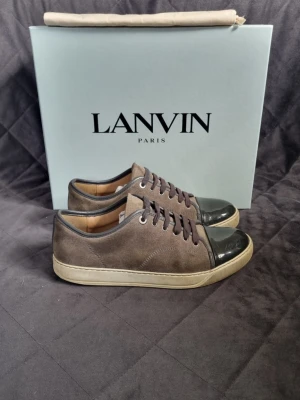 Lanvin - Lanvin Cap Toe sneakers | Storlek: Uk 6 fits 39-40 | Skick: 7,5/10 | Skorna behövs endast tvättas | Tillkommer: Box, nya skosnören och en dustbag | Färg: grå | Nypris: 4999kr | Vårt pris: 1499 kr | Bara att skriva om du har några funderingar! | Välj helst Bring som leveransmetod, eftersom jag bor bredvid en Bring box! Då går leveransen 100 % snabbare, Instabox funkar också!