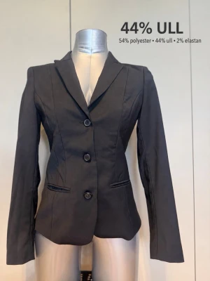 Tiger of Sweden figursydd ullkavaj – XS/34 - 🖤 Elegant kavaj med markerad midja och en mycket smickrande passform ✨ Tidlös modell som passar lika bra till kontoret som till fest 🧵 Material: 44% ull, 54% polyester, 2% elastan 🤍 Fodrad med viskosblandning 🇸🇪 Tiger of Sweden, modell Venima 📏 Storlek 34 / XS 