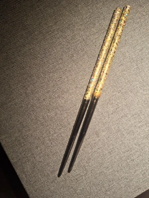 Glittriga hårpinnar i svart och guld - Säljer ett par snygga hårpinnar med svart nedre del och glittrig guld- och silverfärgad ovandel. Perfekta för att fixa en cool uppsättning eller bara som statement-accessoar i håret. Materialet är troligtvis plast med glitterdetaljer.