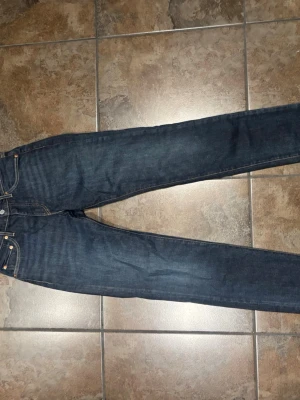 Mörkblå raka jeans - Snygga mörkblå jeans med rak passform och klassiska fem fickor. Jeansen har kontrastsömmar och knappgylf. Perfekta för en avslappnad och stilren look. Materialet är kraftig denim i bomull. 28 32
