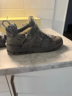 Axel Arigato sneakers  - Säljer ett par grå sneakers från Axel Arigato med chunky sula och slitna detaljer. Passa på säljer billigt, nypris: 3800kr!