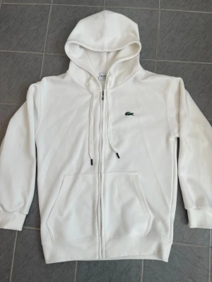 Vit zip hoodie från Lacoste - Vit hoodie från Lacoste med dragkedja. Har endast använts en gång och har storleken S 