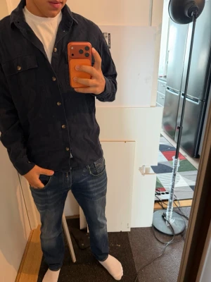 Mörkblå overshirt - Säljer en mörkblå overshirt med snygga knappar, perfekt plagg för såväl vardag som utgång. Storlek M