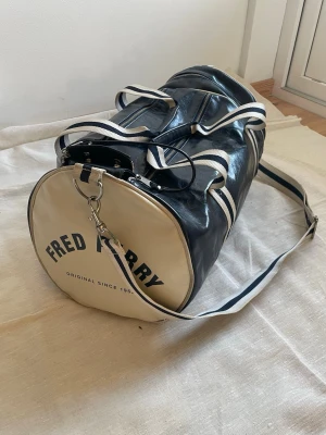 Mörkblå Fred Perry duffelbag  - Snygg trendig duffelbag väska från Fred Perry | Skick: Bra (slitage se bilder) |Modellen är 175 cm och väger 65 kg | Hör av dig vid funderingar ⁉️
