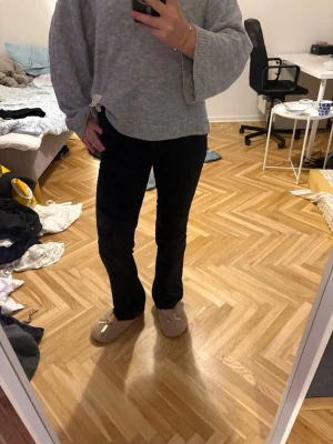 Svarta kostymbyxor med bootcut - Säljer ett par svarta kostymbyxor med bootcut-modell och hög midja. Byxorna har klassisk passform, bälteshällor och stängs med knapp och dragkedja. Perfekta till en snygg och stilren look.
