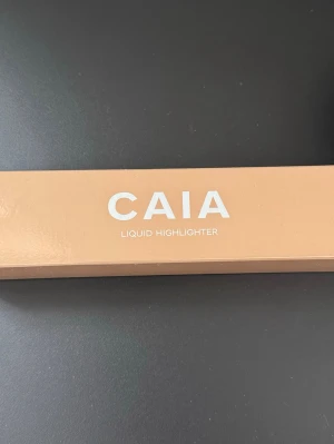 Helt ny! CAIA Liquid Highlighter  - Få ett magiskt Glow med CAIAs flytande highlighter i fina nyansen Bronzed Beach, som beskrivs som champagne-rosé med varm underton. Helt ny/oöppnad och innehåller 50 ml.