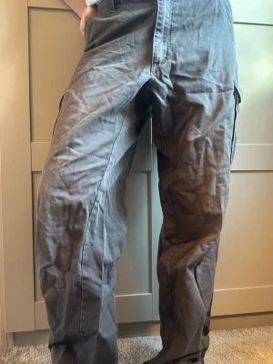 Grå cargobyxor med fickor - Säljer ett par grå cargo byxor.