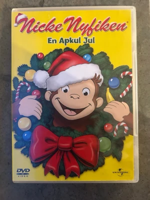 Nicke nyfiken: En apkul jul DVD - Nicke Nyfiken och Mannen med den gula hatten har riktigt roligt medan de räknar ner till julafton. Det finns bara ett bekymmer: ingen av dem kan komma på vad han ska ge den andre i julklapp.  Finns på språk: Svenska, Danska, Norska, Finska, Engelska, Franska, Holländska, Grekiska  OBS!! skivorna är begagnade så det kan förekomma repor/hairlines på skivorna, men då jag kollar igenom alla filmer jag säljer garanterar jag att alla funkar felfritt om inget annat står! :)