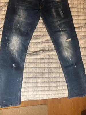 Blåa jeans med slitningar  - Säljer ett par blå jeans med raka ben och slitna detaljer samt ljusa partier framtill perfekt för en som vill ha lite slitningar på jeansen men inte överdrivet mycket.  Köpte från farfetch. Kan ej använda dessa längre på grund av att dem är små för mig. Har fått väldigt många fina komplimanger. Många tycker att dem sitter bra och ser bra ut. Kan gå med på att sänka priset beroende på hur det går. 