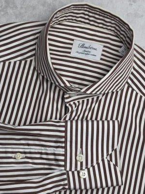Stenströms Slimline Twofold skjorta randig brun/vit storlek S / 38 / 15 - Randig skjorta från Stenströms i Slimline-passform. Klassisk brun och vit design med tydliga vertikala ränder och cut away-krage. Tillverkad i 100% dubbeltvinnad Twofold Super Cotton för en slät och exklusiv kvalitet.  Storlek S / 38 / 15  Slimline  Mycket fint skick.  Mått  Bröstbredd: ca 49 cm Plagglängd: ca 76 cm Axelbredd: ca 44 cm Ärmlängd: ca 66 cm  Material 100% bomull Twofold Super Cotton  Varan är begagnad och säljs i befintligt skick, se bilder för detaljer.