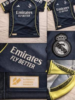 Real Madrid mörkblå matchtröja - Mörkblå Real Madrid matchtröja från Adidas med gula detaljer och klubbmärke på bröstet. Tröjan har vita Adidas-ränder på axlarna, sponsortryck framtill och autenticitetsmärke. Tillverkad i funktionsmaterial, perfekt för fotbollsträning. 🚨Svarta Real shorts ingår🚨