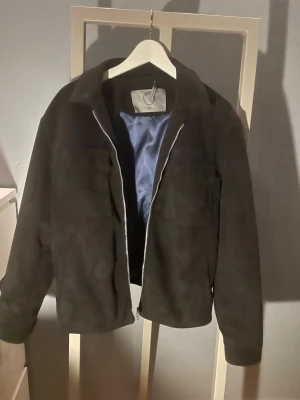 Human scales suede jacket - Säljer en stilren human scales suede jacket. Den är i mycket fint skick. Det är Mjukt mockaliknande material med silverfärgad dragkedja och mörkblått innerfoder. Perfekt till både vardag och lite mer uppklädda outfits. Det är ett litet hål i innefodret och lappen har lossnat på ena sidan men det påverkar inte utseendet.