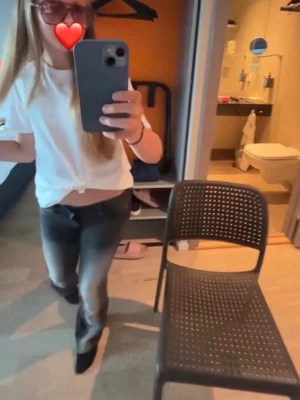 Svarta bootcut jeans med tryck - Säljer ett par svarta bootcut jeans med snygg slitning och ett lila tryck på bakfickan. Jeansen har låg midja och klassisk femficksdesign. Perfekta för dig som gillar en avslappnad men trendig stil.    Köp helst på min jeansen på vinted 11.ellie.12 jag är bättre på det!
