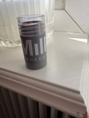 Milk Makeup Lip + Cheek Stick Dash - Milk Makeup Lip + Cheek Stick i färgen Dash. En krämig rouge i stickformat som även kan användas på läpparna. Färgen är en djup bärig nyans och förpackningen är grå med tydlig logga. Perfekt att ha i väskan för snabba touch-ups. Knappt använt