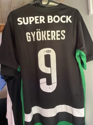 Sporting CP matchtröja Gyökeres 9 - Säljer en Sporting Lissabon hemma tröja från säsongen 24/25 med gyökeres 9 på ryggen. Jag har inte använt den något utan den har bara hängt i mitt rum men klubbemblemet har lossnat lite men går säkert stryka fast igen ( därav priset )