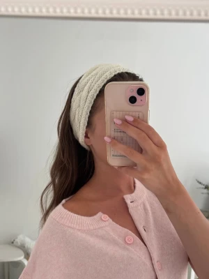Vitt/off-white stickat/handvirkat hårband med flätmönster - Säljer ett supermysigt vitt virkat hårband med snyggt flätmönster. Perfekt för att hålla håret på plats och ge en chill vibe till din look. Materialet är mjukt och stretchigt, vilket gör det bekvämt att bära hela dagen. Köpt på en julmarknad och endast testad. 