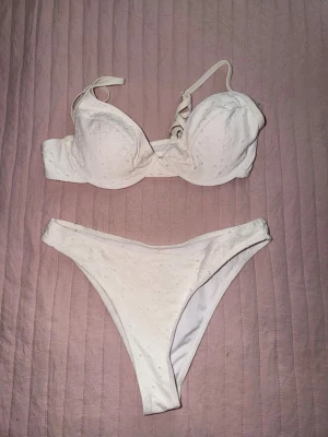 Vit bikini med broderade detaljer - Bikini med överdel och underdel. Överdelen har bygel och knäppning bak. Från Shein