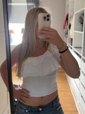 Vit offshoulder topp med volang - Säljer en söt vit offshoulder topp med bred volangdetalj över bysten från Zara. Toppen är croppad och har en tajt passform💕 