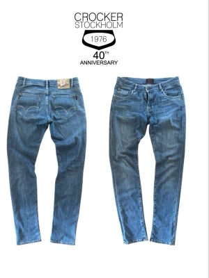 Blå jeans från Crocker - Snygga blå jeans från Crocker med klassisk femficksmodell och raka ben. Jeansen har ljus tvätt, kontrastsömmar och detaljerade bakfickor med dekorativ söm. Perfekta för en avslappnad och trendig stil.