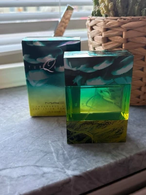 MAC  Eau de Parfum - MAC Eau de Parfum i en unik, fyrkantig flaska med grön och turkos gradient. Flaskan har ett konstnärligt mönster och matchande förpackning. Modern design som sticker ut på parfymhyllan. Lätt fräsch  Sommarparfym. Ny 