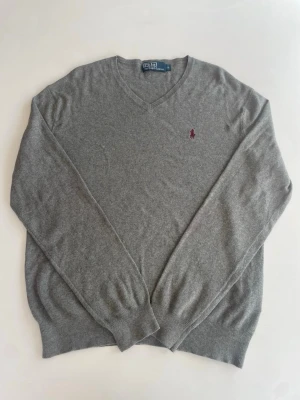 Grå stickad tröja Polo Ralph Lauren - En fin grå stickad tröja från Ralph lauren med röd logga. Hör av er vid funderingar!