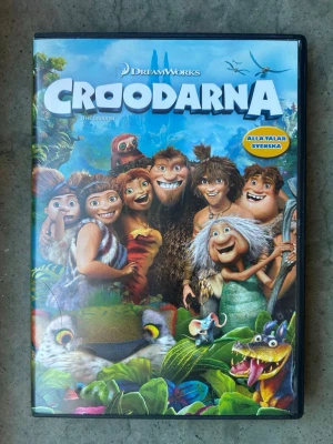 Croodarna DVD - DVD-film med DreamWorks animerade äventyr Croodarna. Filmen handlar om världens första familj som ger sig ut på sitt livs resa när grottan de kallar hem förstörs. De upptäcker en otrolig ny värld fylld av fantastiska landskap och märkliga varelser.  Finns på språk: Svenska, Engelska   OBS!! skivorna är begagnade så det kan förekomma repor/hairlines på skivorna, men då jag kollar igenom alla filmer jag säljer garanterar jag att alla funkar felfritt om inget annat står! :)