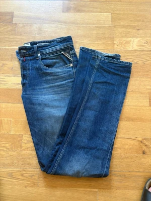 Mörkblå jeans från replay  - Säljer ett par mörkblå jeans med raka ben och klassisk femficksmodell. Jeansen har snygga slitningar och kontrastsömmar. Materialet är denim i bomull och passformen är normal. Perfekta till en avslappnad stil.