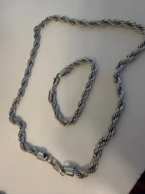 Silver cordell 8 mm - Säljer ett stilrent halsband i silver metall med tvinnad kedja och robust lås. Halsbandet har en modern och chunky design som sticker ut och passar perfekt för dig som gillar att synas. Matchande armband ingår.