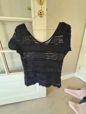 Marinblå spetsblus med v-ringning - Tröjan e marinblå och genomskinlig passar parfelt med ett linne under på sommaren, tröjan är i väldigt bra skick och den e off shoulder, pris kan diskuteras! Den e i S