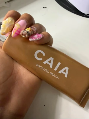 CAIA Bronzed Beach bronzer - Säljer en CAIA Bronzed Beach bronzer i tub med silvrigt lock. Färgen är varm brun och formulan är flytande, perfekt för att skapa en solkysst look. Tuben är smidig att ta med i väskan och enkel att applicera för en naturlig glow.