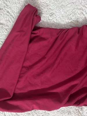Vinröd axelbandslös klänning - Säljer en vinröd axelbandslös klänning i mjukt tyg. Klänningen har en enkel och stilren design som passar perfekt till olika tillfällen. Tyget känns lent och följsamt mot huden.