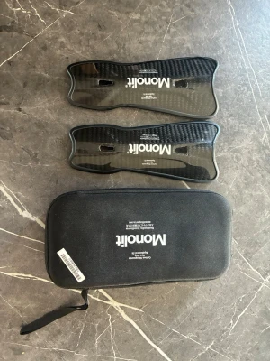 Monolit benskydd i kolfiber - Säljer ett par svarta benskydd från Monolit i kolfiber med ergonomisk form och vadderad insida. Kommer med tillhörande svart förvaringsväska med dragkedja och handtag. Perfekta för dig som vill ha lätta och tåliga skydd till fotboll eller annan sport.Säljer nu mina monolit benskydd eftersom jag inte använder dom längre.   Utan tvekan dom skönaste benskydden jag använt eftersom dom är så lätta, vilket gör att man knappt känner av dom. 
