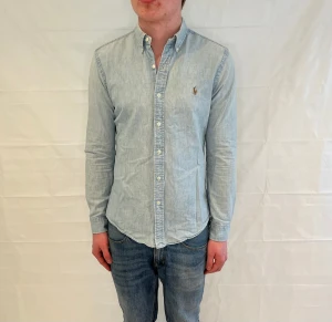 Polo Ralph Lauren Slim Fit Denim Shirt Light Blue Men's - Slim fit denimskjorta i ljusblått, 100% bomull. Begagnad i mycket fint skick.