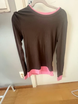 Brun långärmad tröja med rosa detaljer - Snygg långärmad tröja i brunt med rosa detaljer vid hals, från Zara och aldrig använd!