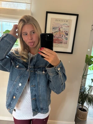  Fin  jeansjacka - Säljer en fin blå jeansjacka. Jackan har en tidlös design utan krage och är perfekt att slänga över en t-shirt för en avslappnad look. Fickor på sidorna finns och knappar för knäppe. Använd ca 3ggr men säljer nu då jag köpt en ny i en annan färg❣️