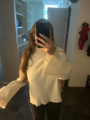 Vit/creme färgad stickad tröja  - Stickad polotröja med hög ribbad krage, mjuk och skön och i fint skick, men har en sminkrand (som jag brukar vika in) se bild.